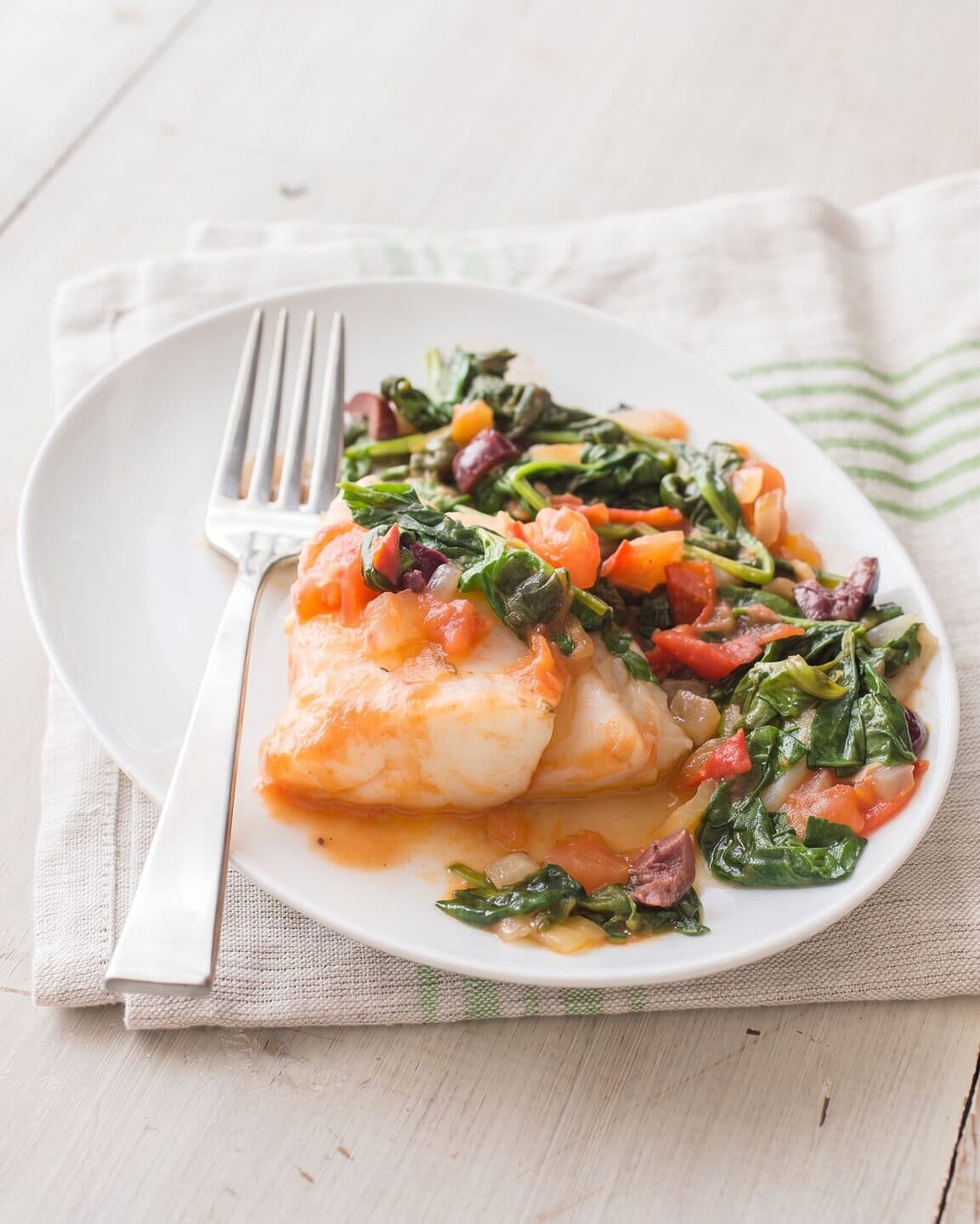 Pesce con spinaci, pomodoro e olive